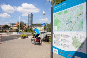 Radfahrer von hinten, Paradiesbrücke in Jena mit Schild Radwanderwege in Jena, Blick in Richtung Innenstadt