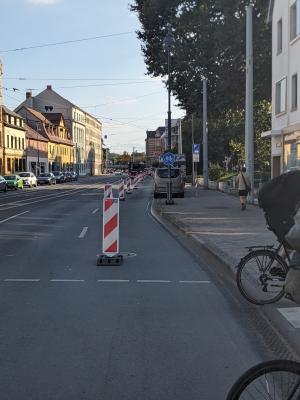 Bild vom Popup-Radweg im Löbdergraben Jena, abgetrennt durch rot-weiße Baken
