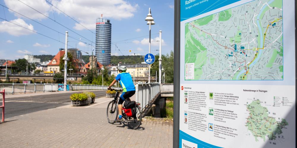 Radfahrer von hinten, Paradiesbrücke in Jena mit Schild Radwanderwege in Jena, Blick in Richtung Innenstadt