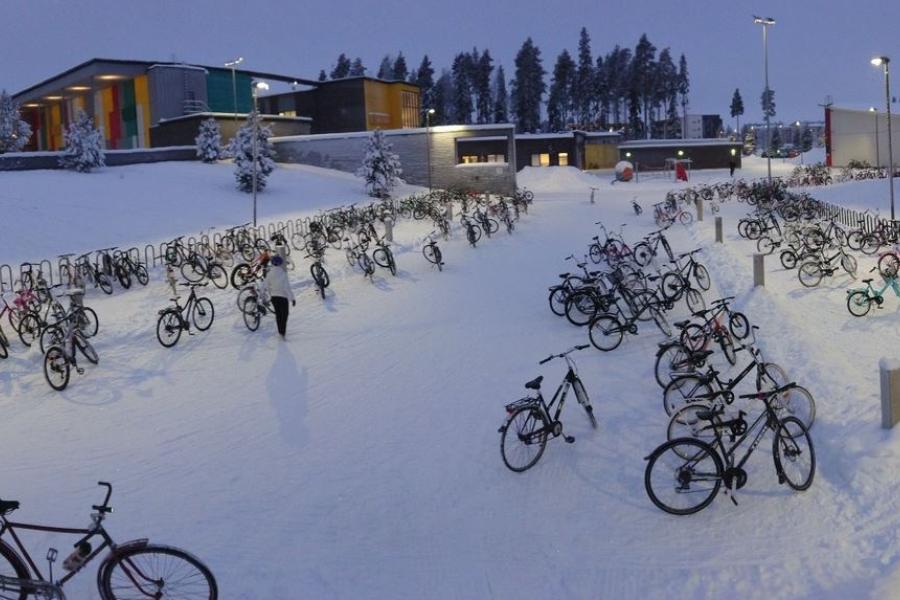 Gebäude und parkende Fahrräder auf einem Platz im Winter mit Schnee