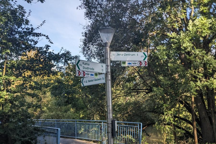 Fahrradwegweiser an der Fußgängerbrücke von Lobeda West nach Göschwitz, Bäume Himmel